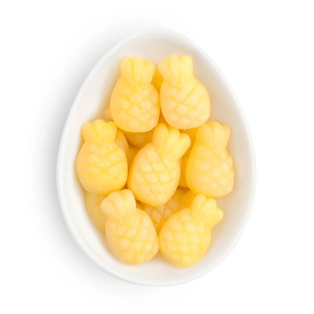 sugarfina Yellow pineapple gummy lollies in a white bowl on a white background sweet as