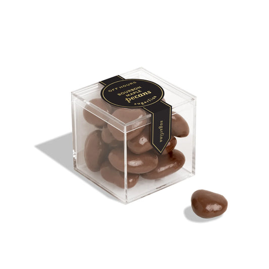 Clear cube box with chocolate-covered pecans and a black label on a white background