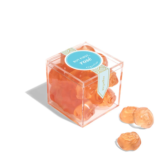 Clear cube packaging with rose-shaped candies on a white background