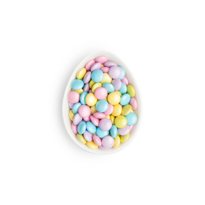 Decorative bowl filled with pastel-colored candies on a white background