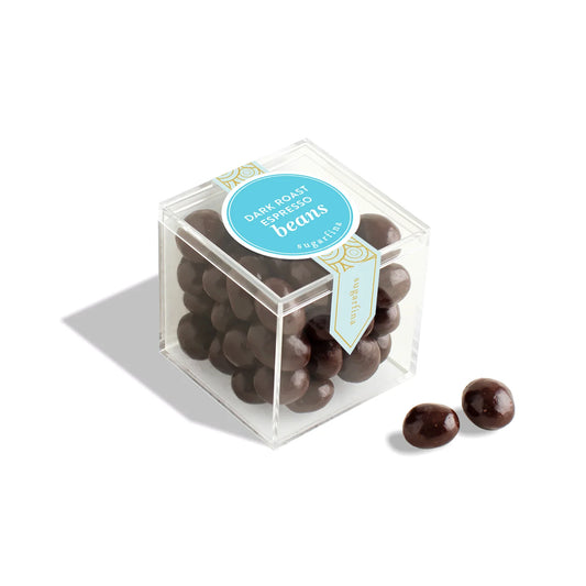 Clear cube container with dark chocolate beans and a blue label on a white background