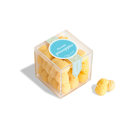 Clear cube box with pineapple-shaped candies and a blue label on a white background