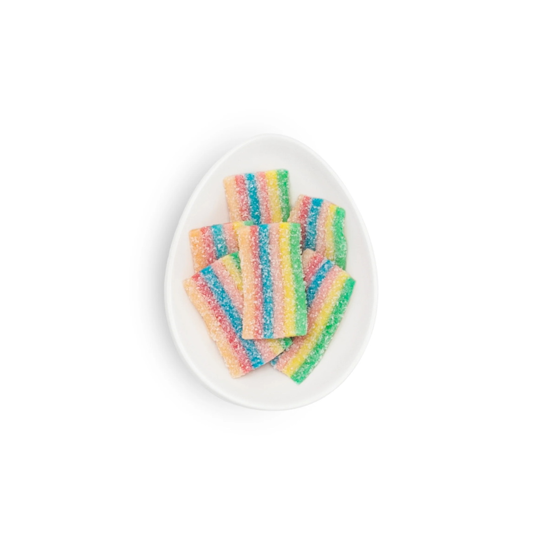 Colorful striped candy on a white plate with a white background