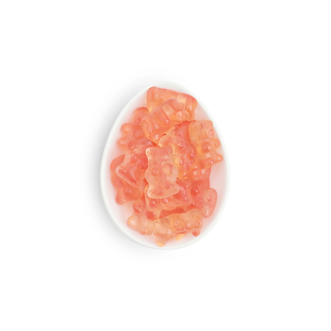 Pink gummy bears on a white plate with a white background