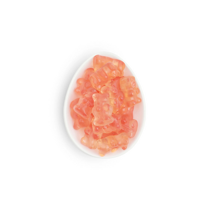 Pink gummy bears on a white plate with a white background