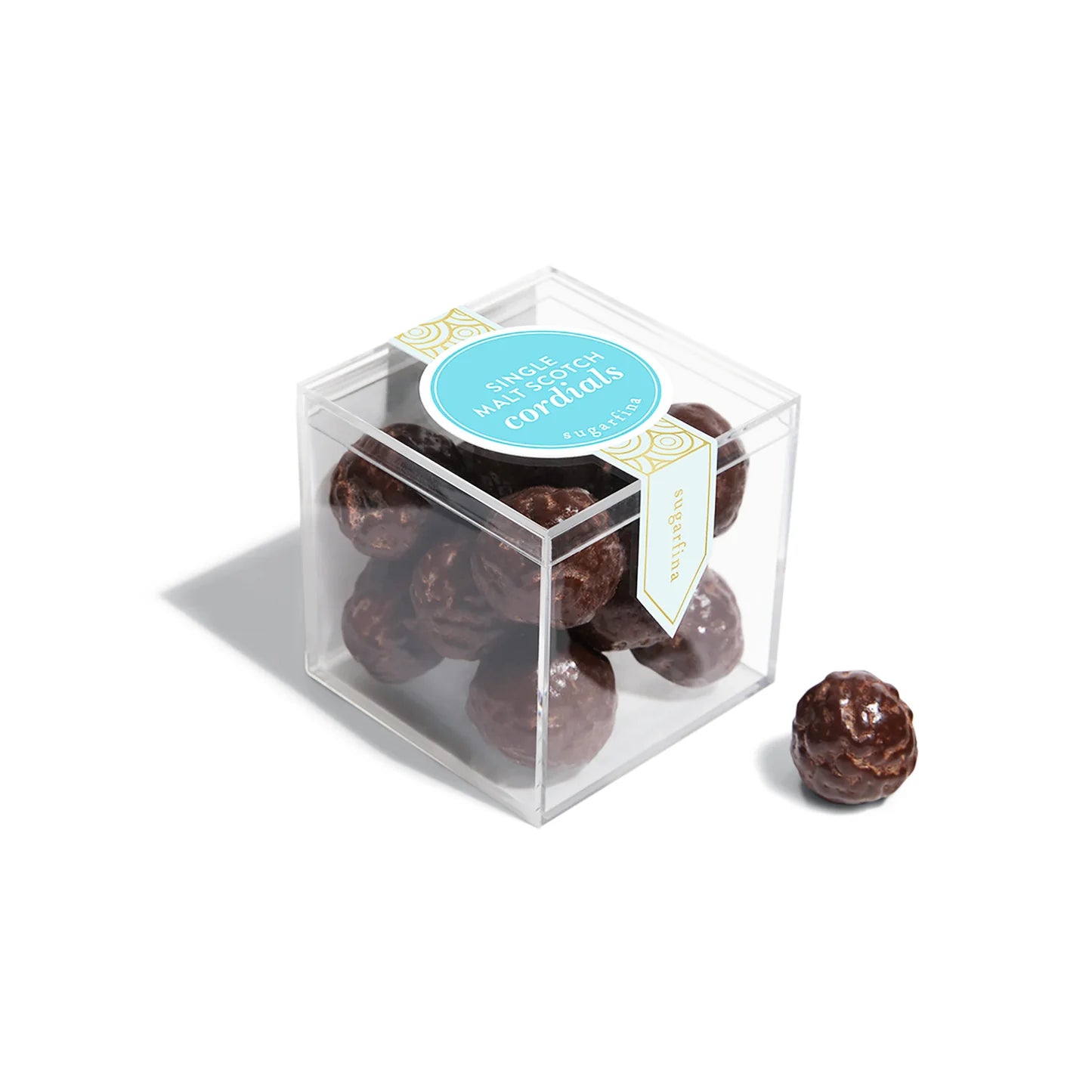 Clear cube box with chocolate cordials and a blue label on a white background