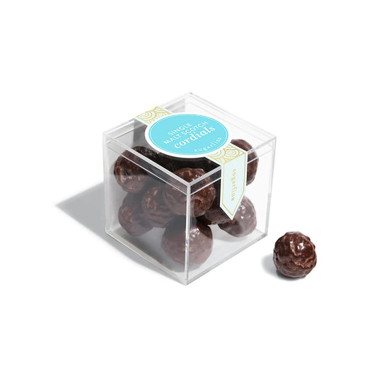 Clear cube box with chocolate cordials and a blue label on a white background
