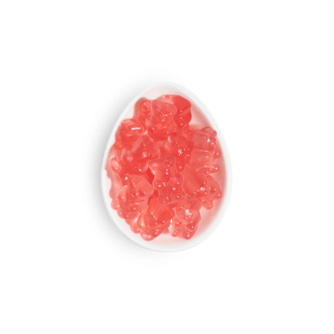 Pink gummy bears on a white plate with a white background