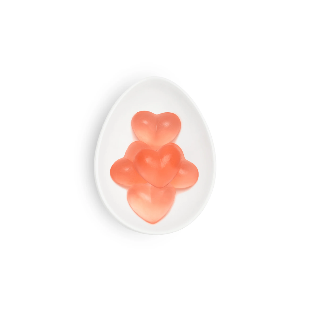 Two pink gummy bears on a white plate with a white background